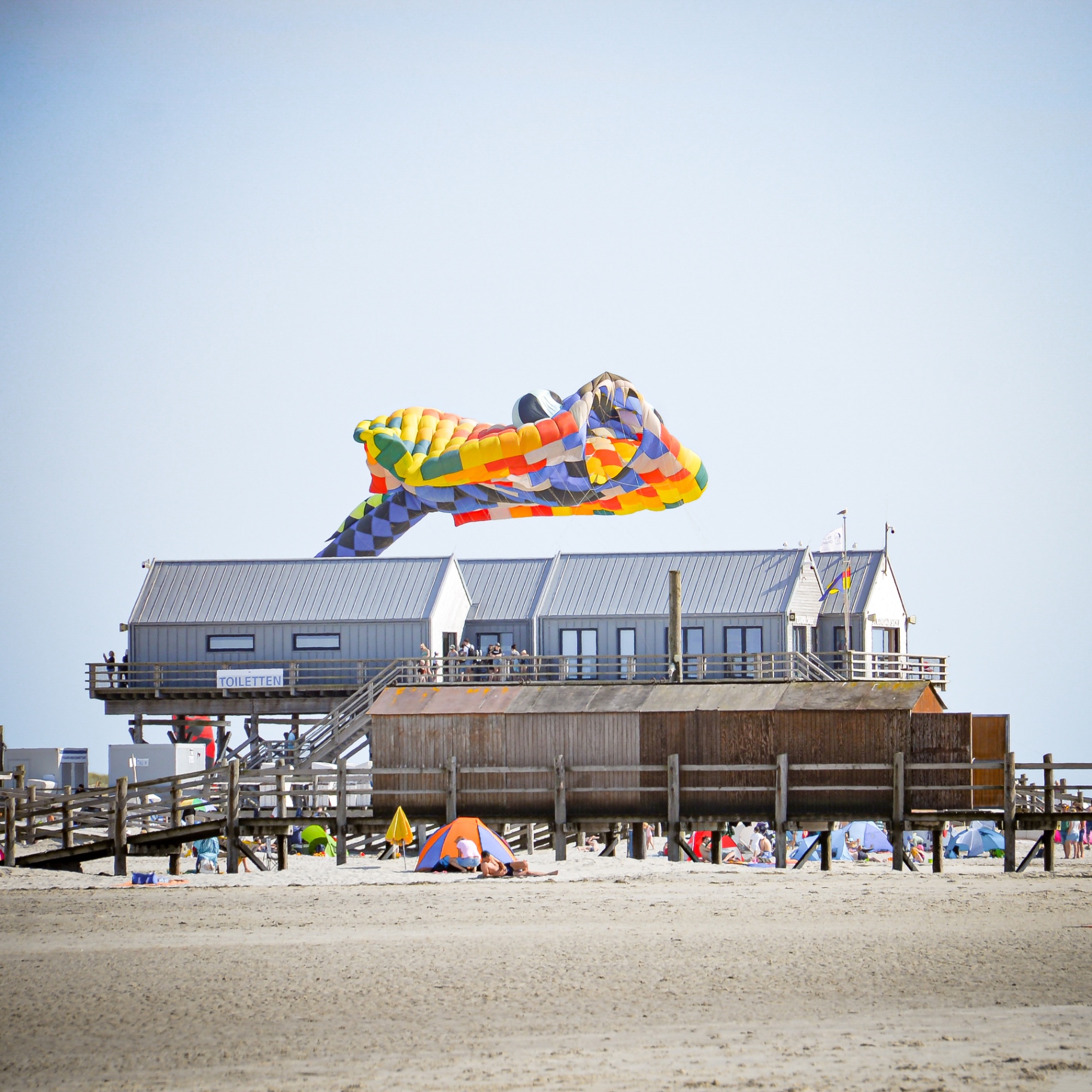 St. Peter-Ording auf Holz - Bunter Drachen über Strandpfahlbau