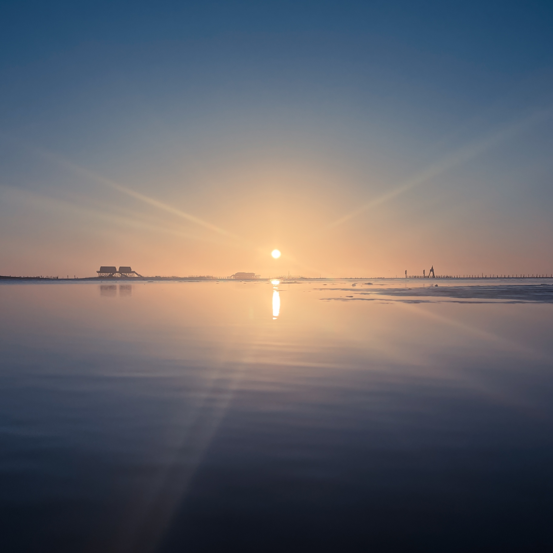 St. Peter-Ording auf Holz - Sonnenaufgang am Horizont