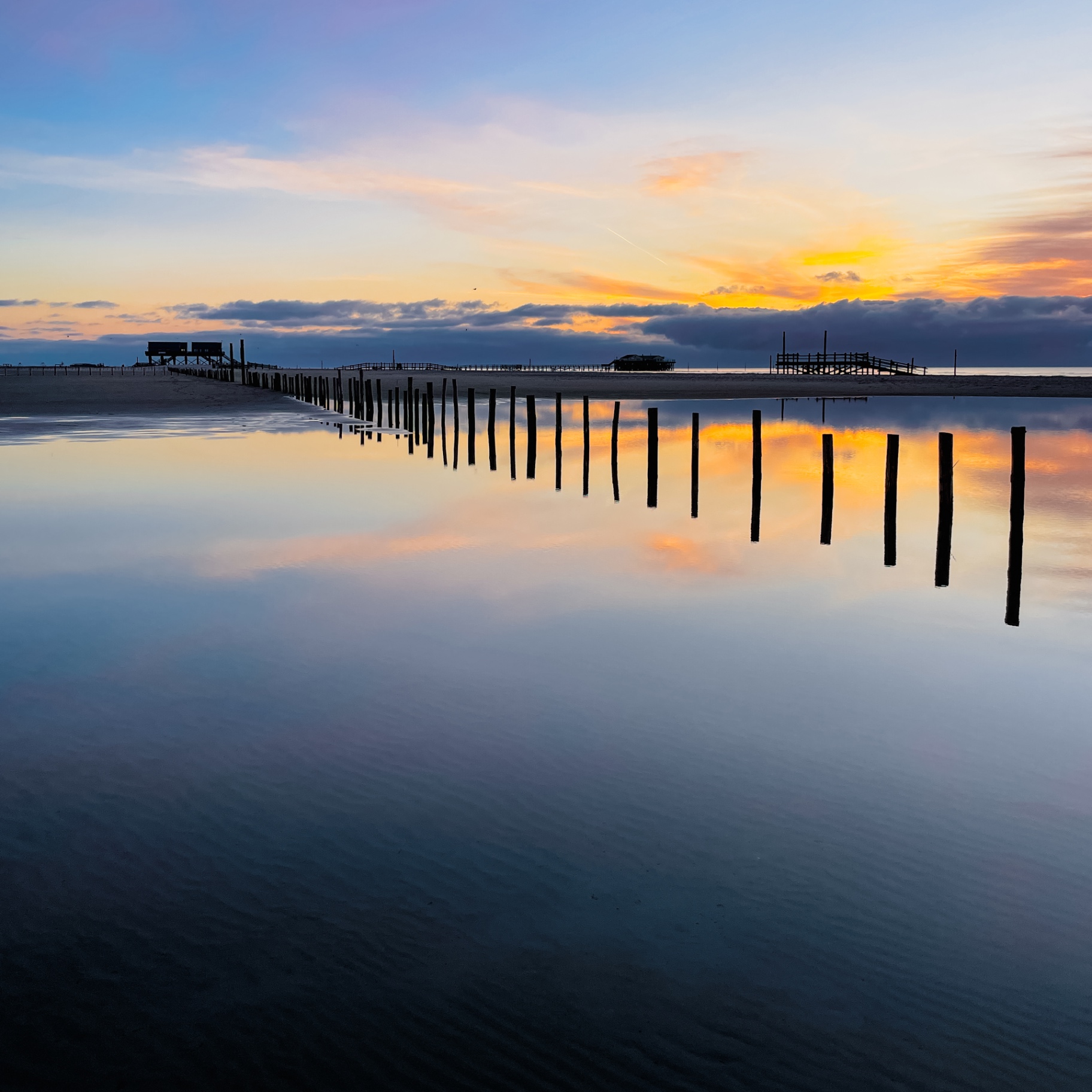 St. Peter-Ording auf Holz - Pfähle im Sonnenuntergang